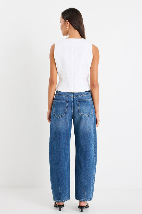 White sleeveless vest top with tie-up front detail, made from structured ramie, styled with high-waisted blue jeans.