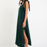 Model wearing a forest-green tie-shoulder midi dress with a relaxed fit and flowy skirt