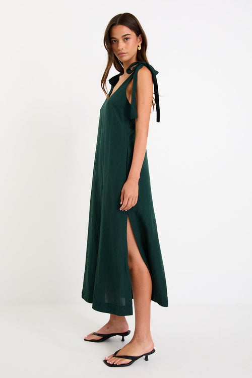 Model wearing a forest-green tie-shoulder midi dress with a relaxed fit and flowy skirt
