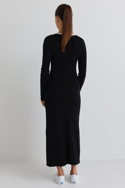 model wears a black knit maxi dress