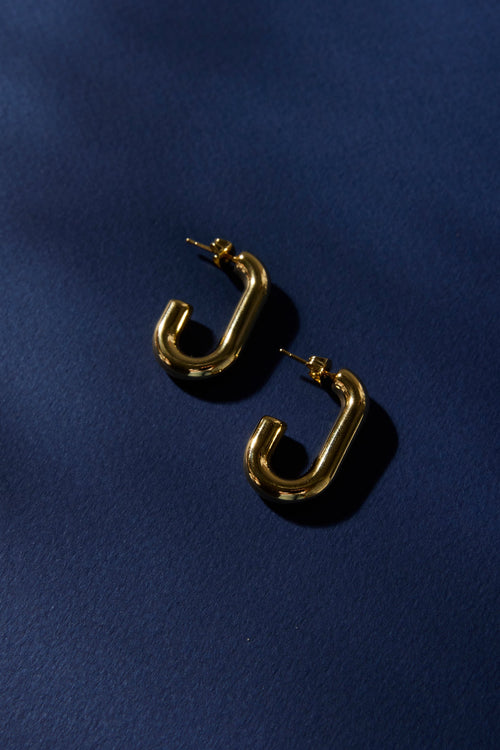 Gold hoop earrings on a dark blue background