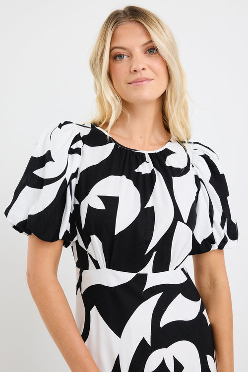 model wears a black and white floral puff sleeve maxi dress