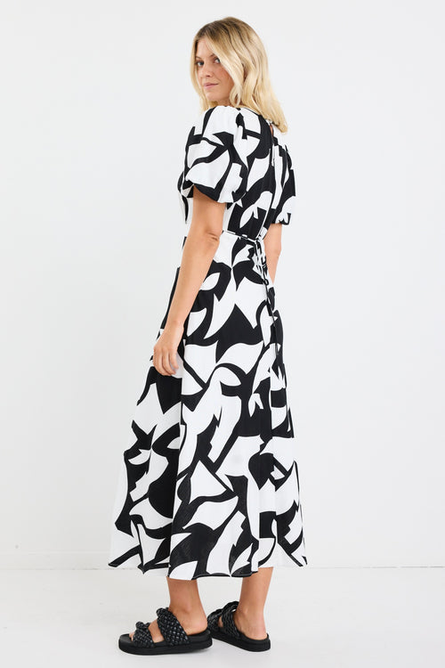 model wears a black and white floral puff sleeve maxi dress