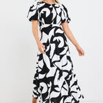 model wears a black and white floral puff sleeve maxi dress