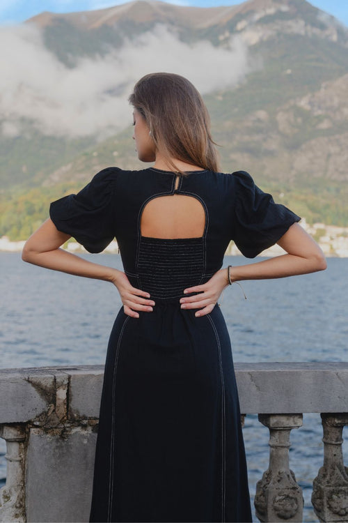 model wears a black midi dress