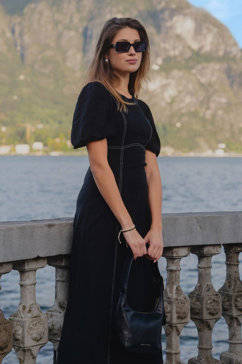 model wears a black midi dress