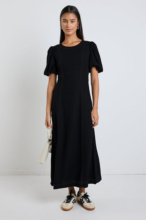 model wears a black midi dress