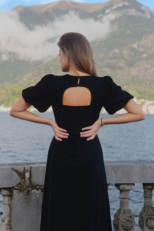 model wears a black midi dress