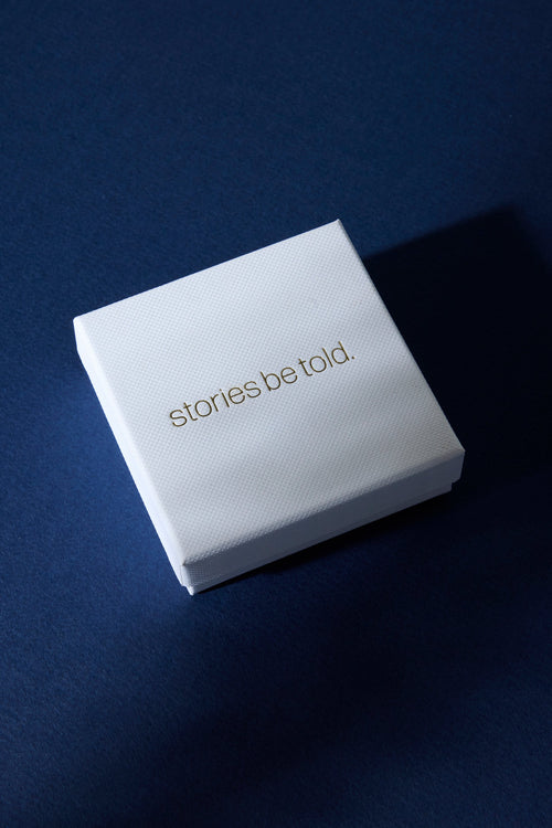 White box with 'stories be told' text on a dark blue background