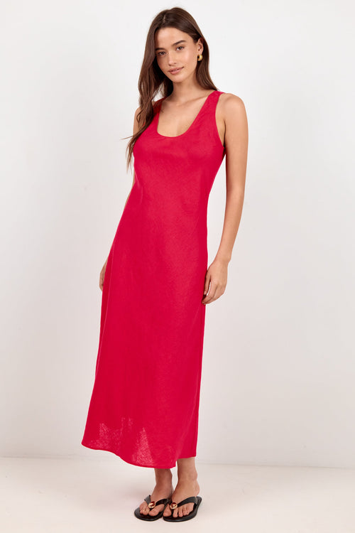 A woman modeling a sleeveless, scoop-neck maxi dress in a vibrant red color, standing against a plain white studio background.