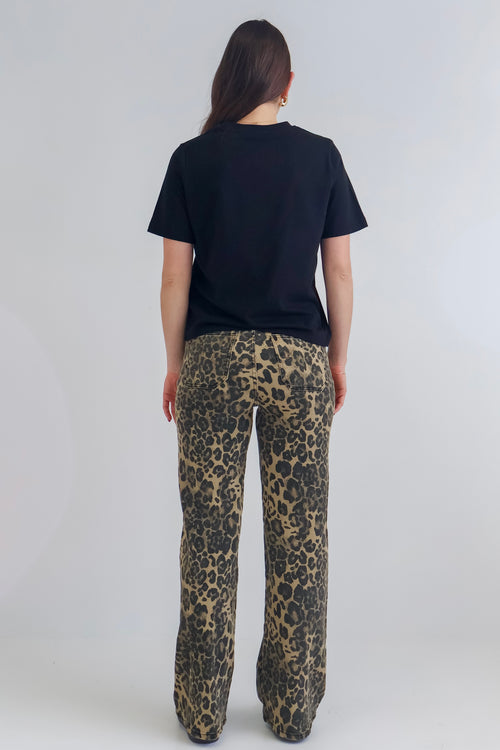woman wearing high-waisted leopard print jeans paired with a black tee.