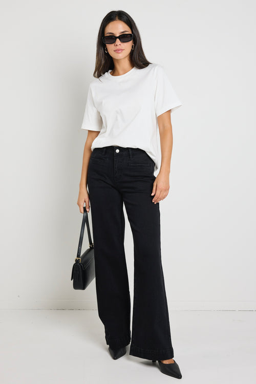 model wearing black jean and white top