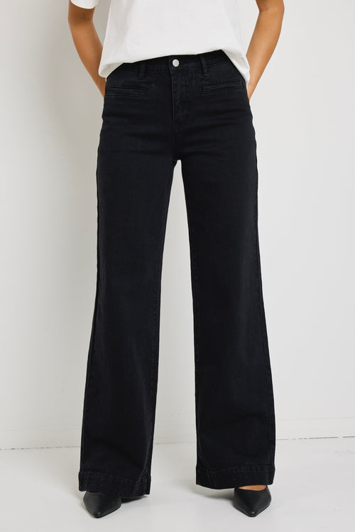 model wearing black jean and white top