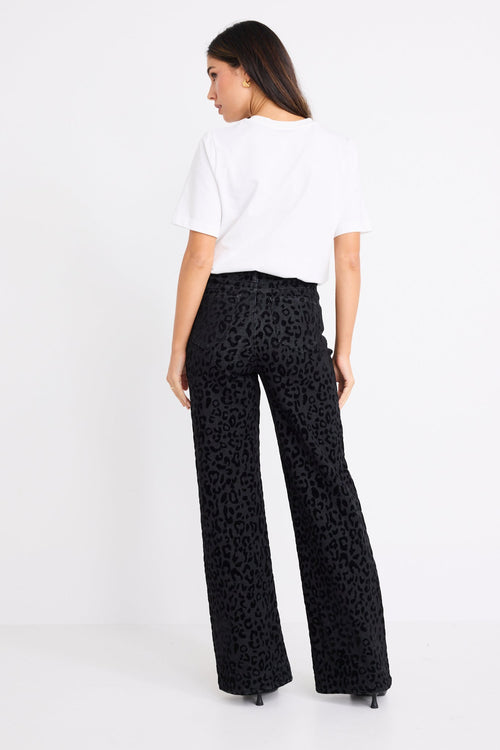 model wearing a black animal jean and white tee