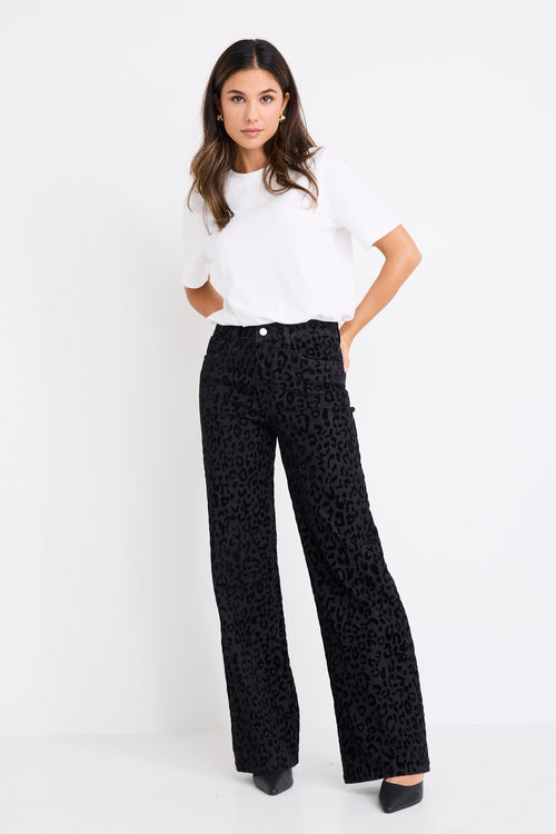 model wearing a black animal jean and white tee