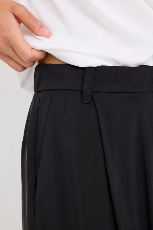 model wears black high waisted pants with a white tee