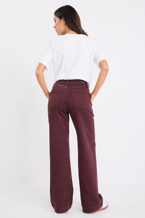 model wears a burgundy jean with white t-shirt