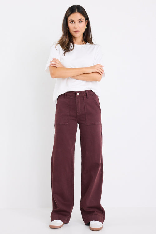 model wears a burgundy jean with white t-shirt