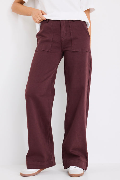 model wears a burgundy jean with white t-shirt