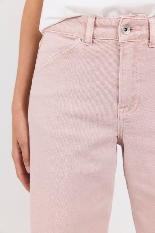 Light pink jeans worn by a person on a white background