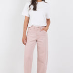 Woman wearing a white t-shirt and pink pants on a white background