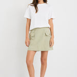 Woman wearing mid-rise chocolate zebra print shorts with an elastic waistband, styled casually with a black top and black sandals.