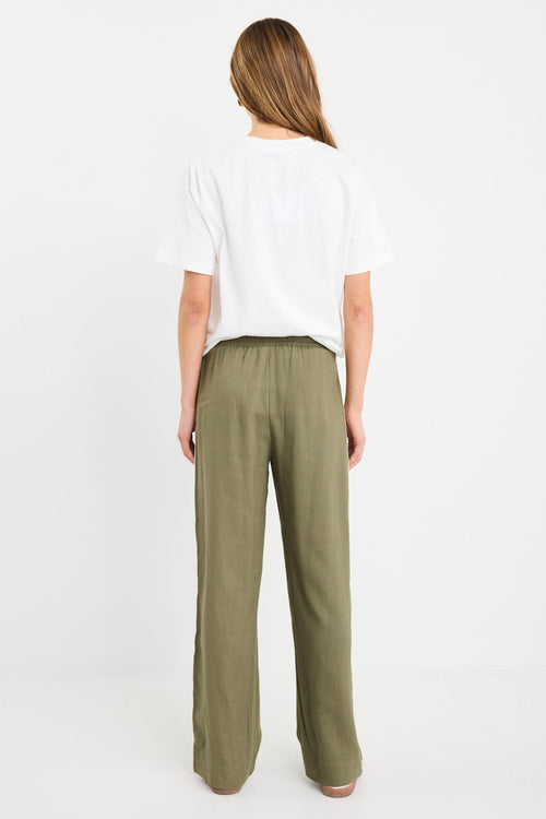 Woman wearing khaki wide-leg drawstring pants with an elastic waist, featuring a relaxed fit and side stripe detail, styled with a plain white tee and white sneakers.
