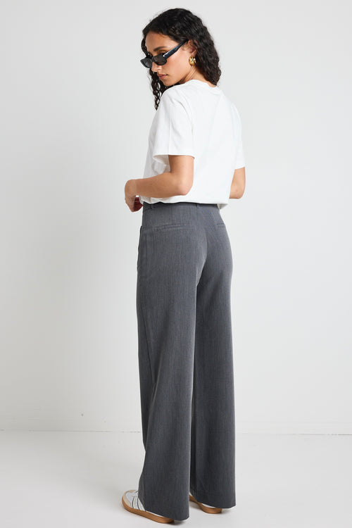 model wears white t-shirt and grey wide leg pants