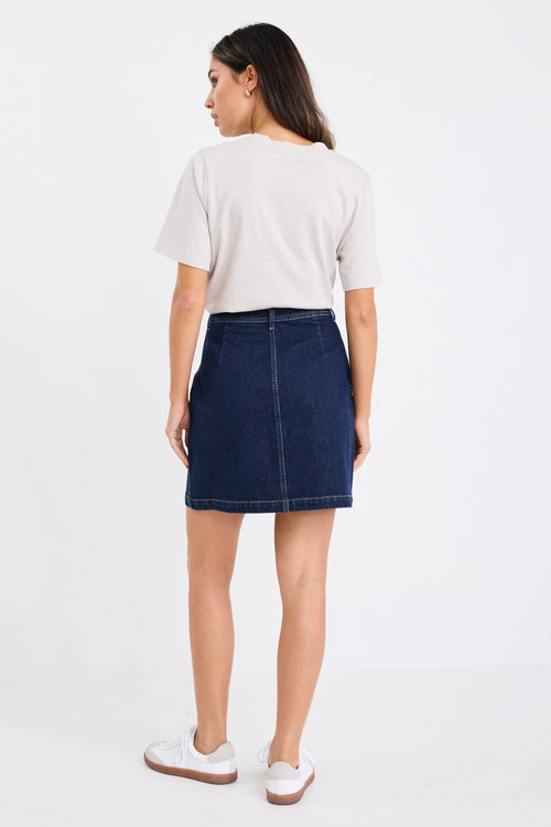 model wears a dark blue denim mini skirt