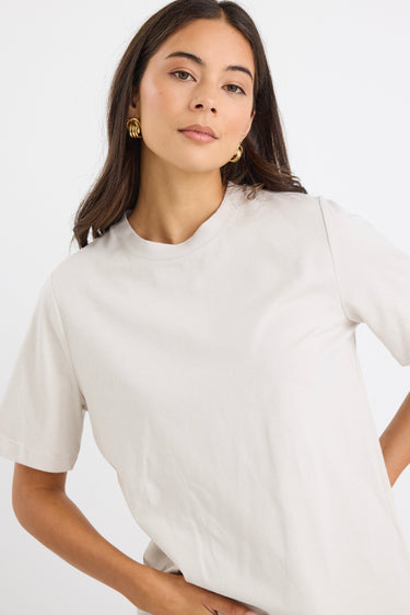 model wears a off white t-shirt with light blue jeans