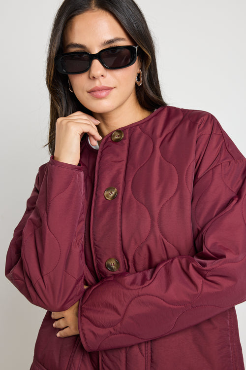 model wears red padded shell jacket