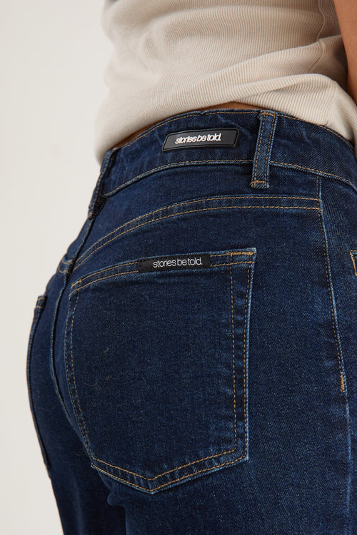 model wearing dark denim jean and white top 