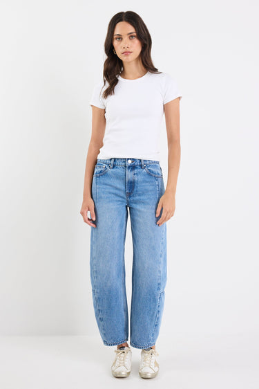 Person wearing a white t-shirt and blue jeans on a white background