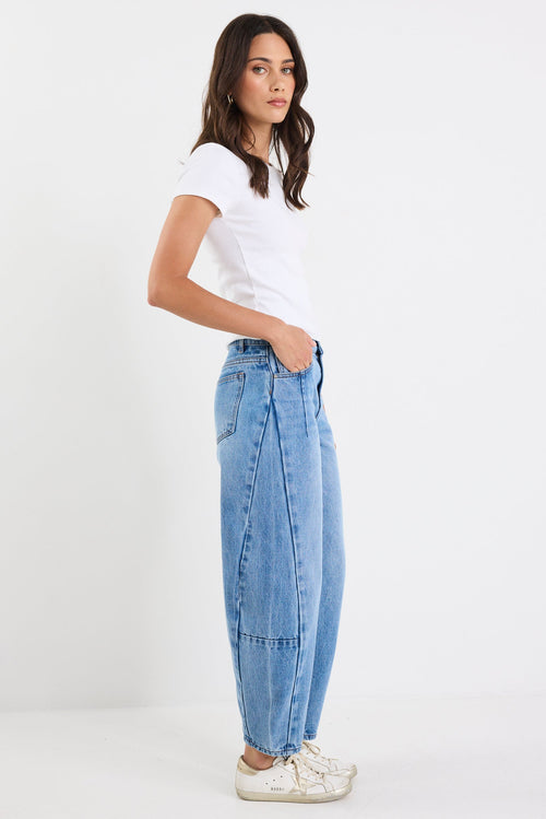 Woman wearing a white t-shirt and blue jeans on a white background