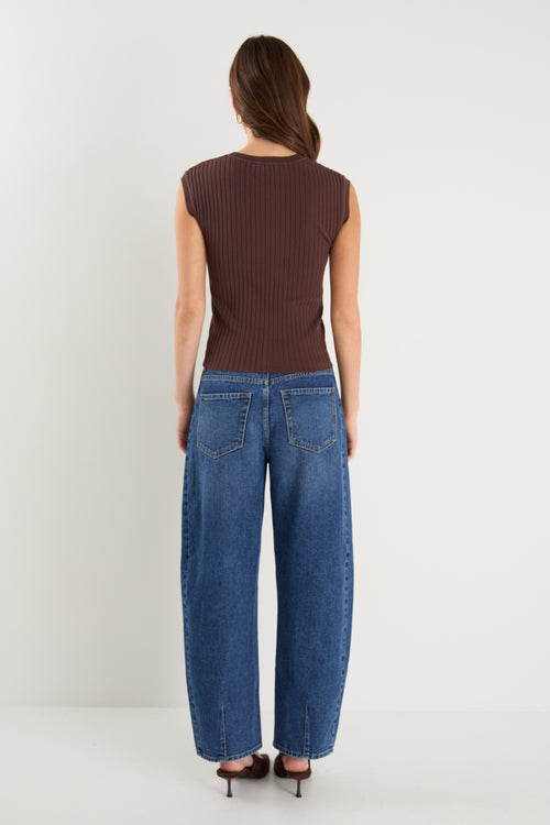 model wears a brown rib knit with blue jeans