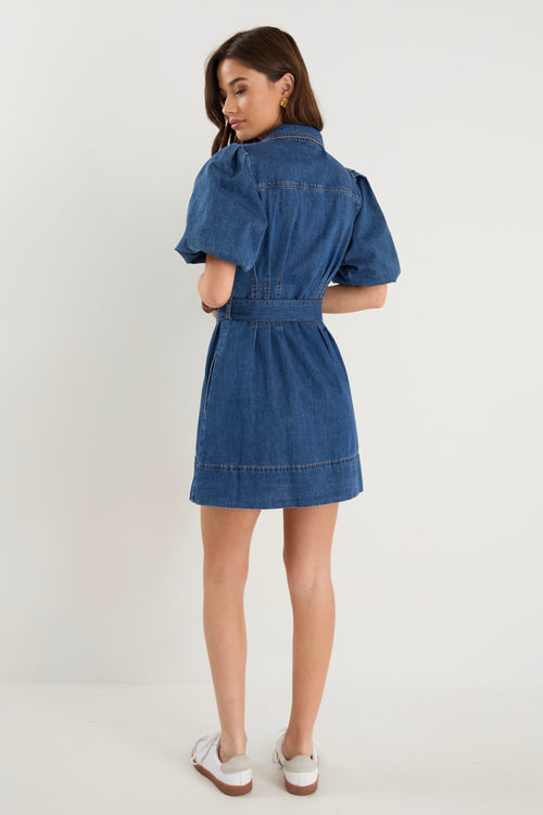 model wears a dark blue denim mini dress