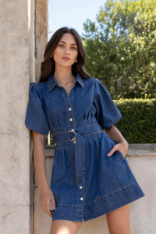 model wears a dark blue denim mini dress 