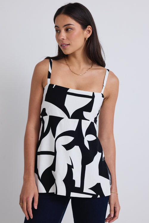 model wears a black and white print top