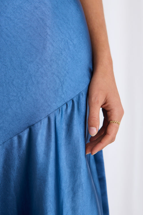 model wears a blue satin maxi dress