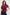 Woman wearing a maroon top and dark jeans on a white background