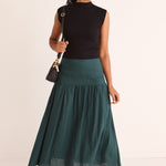 model wears a green linen midi skirt