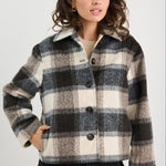 Woman wearing a plaid jacket on a white background