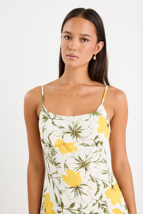 Mini floral bias dress with adjustable straps and a soft, floaty fit, styled with heels and delicate accessories.