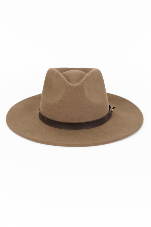 Woman wearing a brown hat against a white background