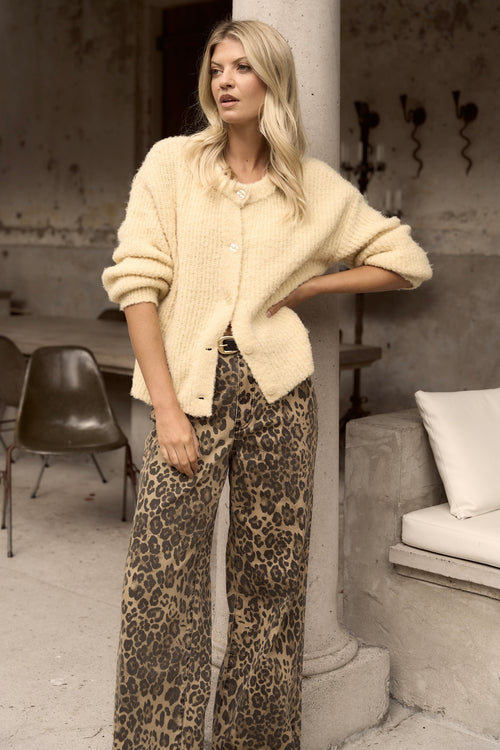 model wears a yellow cardigan with leopard print jeans