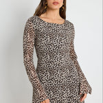 Woman wearing a leopard print mini dress with bell sleeves, styled with sunglasses for a bold and playful look.