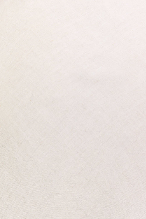 Close-up of a person wearing a white dress with a plain background