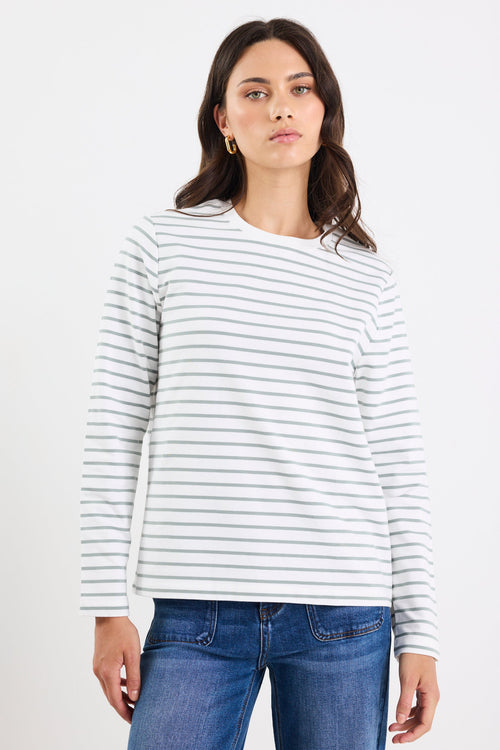 Woman wearing a white and gray striped shirt and blue jeans on a white background