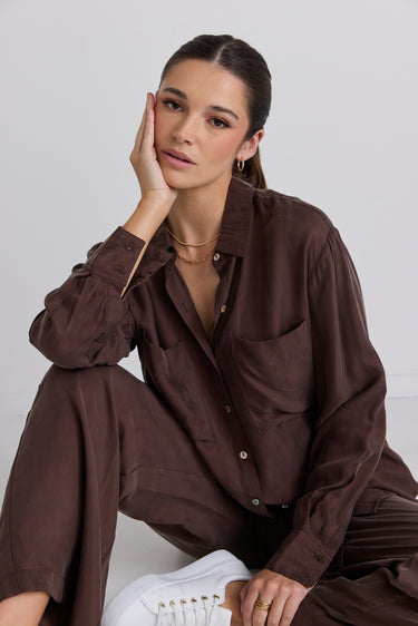 model wears a brown shirt