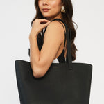 model wears a black tote bag